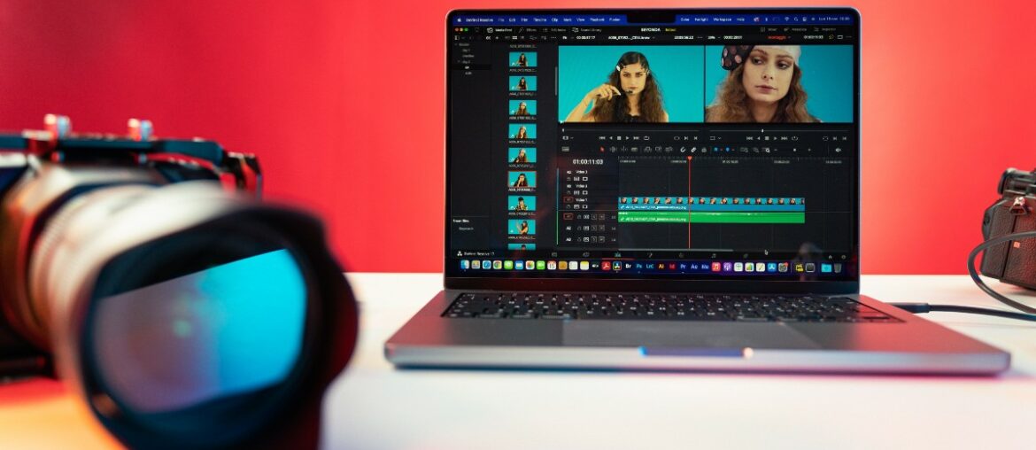 A camera beside a laptop displaying a video of a woman being edited