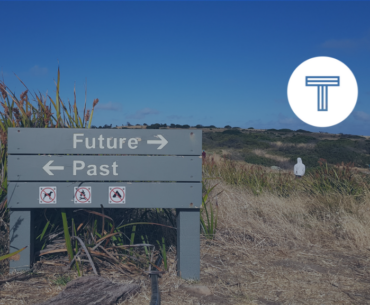 sign on beach with arrows pointing toward future and past